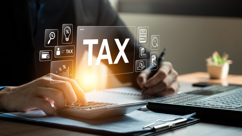 CPA reviewing tax documents with a calculator and laptop